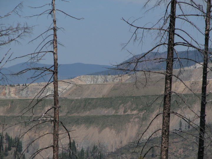 Photo of a a mountain removed and replaced
                    wandering qalong the edge of a as tailings for a
                    copper mine
