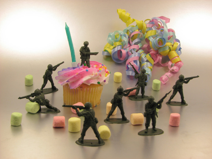 Photo
                  of garish cupcake surrounded by defending plastic toy
                  soldiers