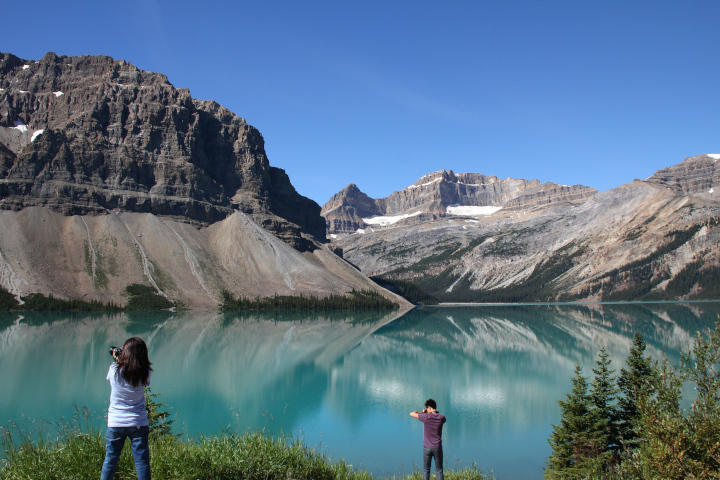 Photo of
              people taking pictures of scenic lake benefiting from
              nature's beauty...